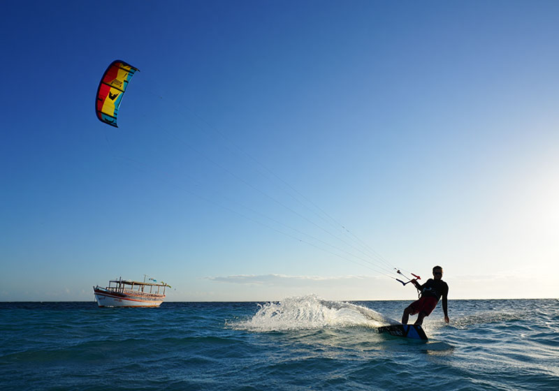 Kitesurfing at Paje beach Zanzibar with traditional dhow boat and perfect wind conditions