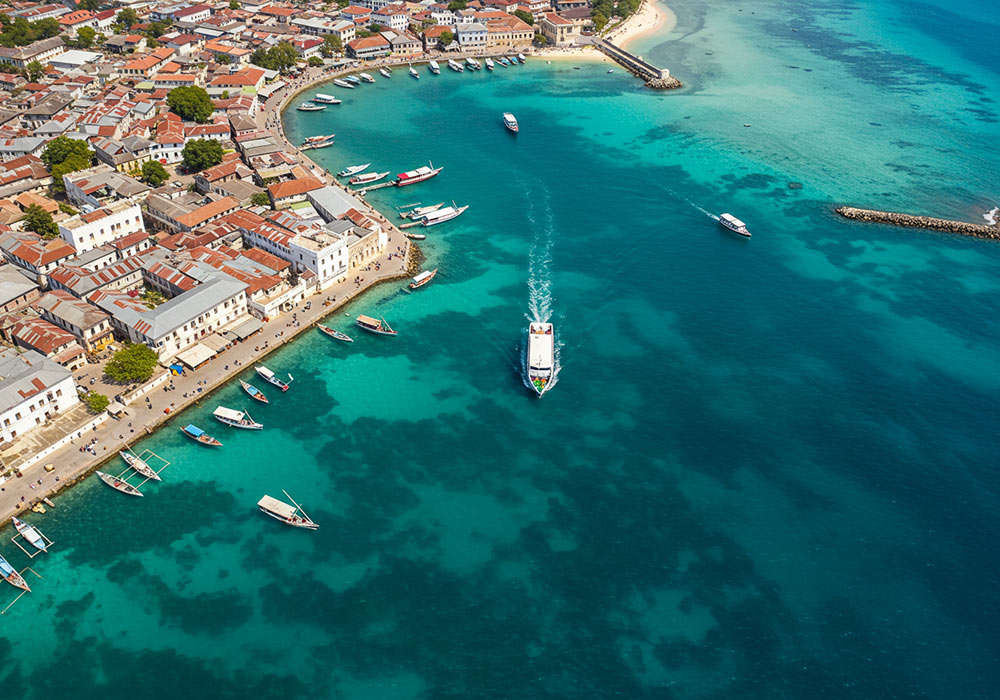 How to Get to Zanzibar - Ferry approaching Stone Town Zanzibar with traditional dhows in harbor