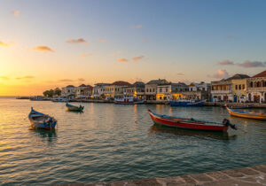 Stone Town Guide - Stone Town Sansibar Uferpromenade mit traditionellen Dau-Booten bei Sonnenuntergang.
