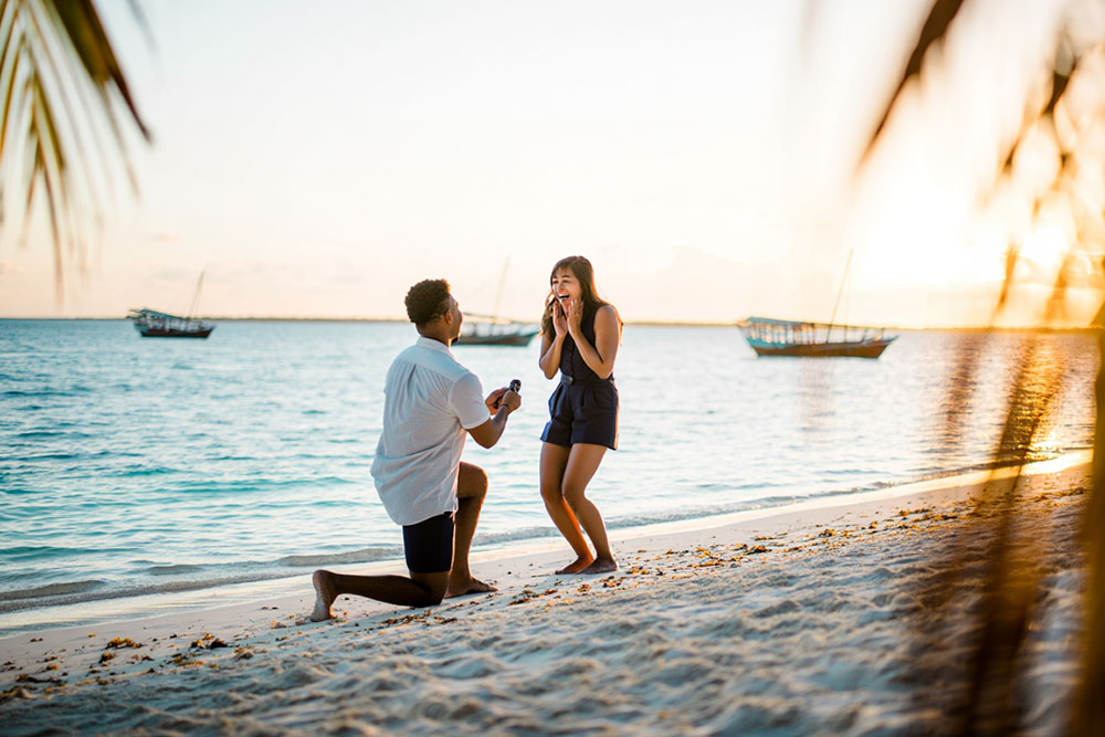 romantic proposal during sunset while traveling as a couple on a quiet beach